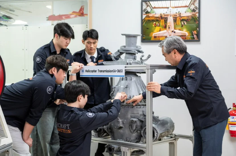 항공기 엔진 장비 앞에서 설명을 듣는 모습