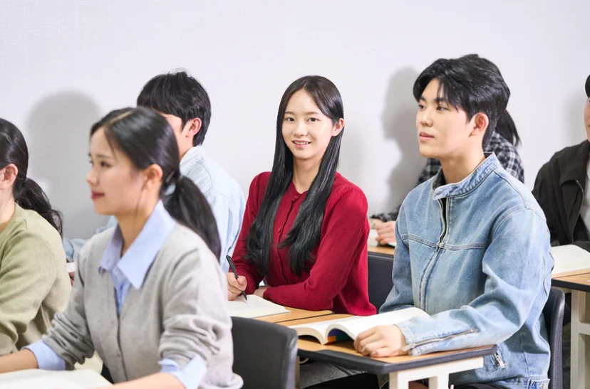 교실에 앉은 여러 사람이 앞쪽을 바라보고 있는 모습