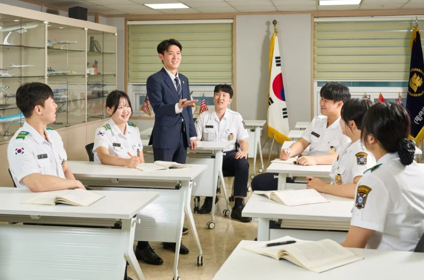 제복을 입은 학생들이 강의실에서 설명을 듣는 모습