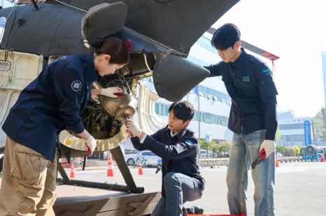 학생들이 항공기 프로펠러와 아래쪽 부품을 점검하는 모습