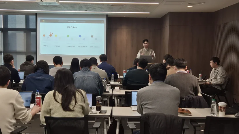 임직원 AI 교육 현장에서 강사가 교육 5단계 슬라이드를 설명하는 모습
