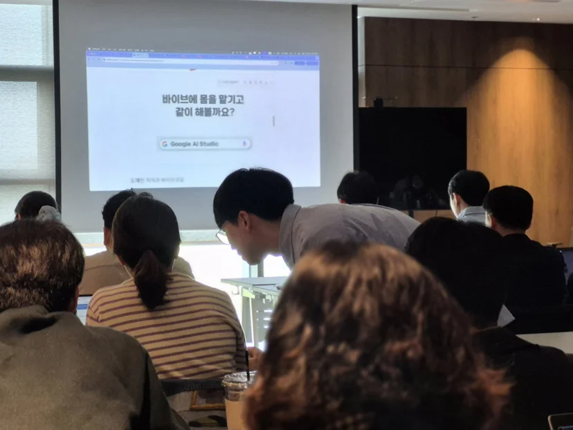 실습 중 강사가 수강생 자리로 가서 화면을 함께 보며 개별로 도와주는 모습