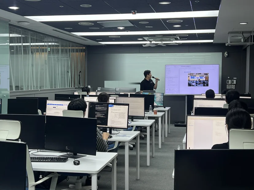 대구경북디자인센터 교육실에서 마이크를 들고 설명하는 주강사와 NIA 10월 AI 활용교육 수강생들
