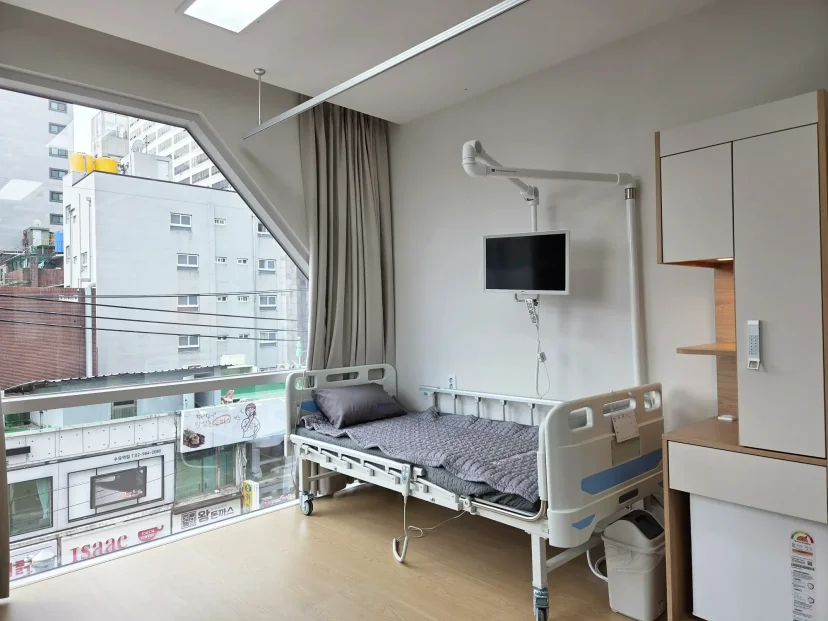 척추수술 후 관리|창밖 시티뷰가 보이는 깔끔한 병원 입원실 내부
