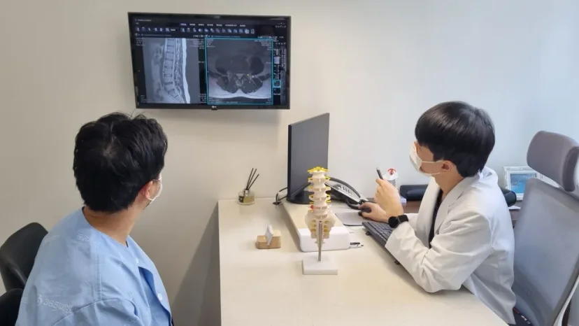 자전거·이륜차 사고|의사가 환자에게 허리 MRI 결과를 설명하는 진료 장면