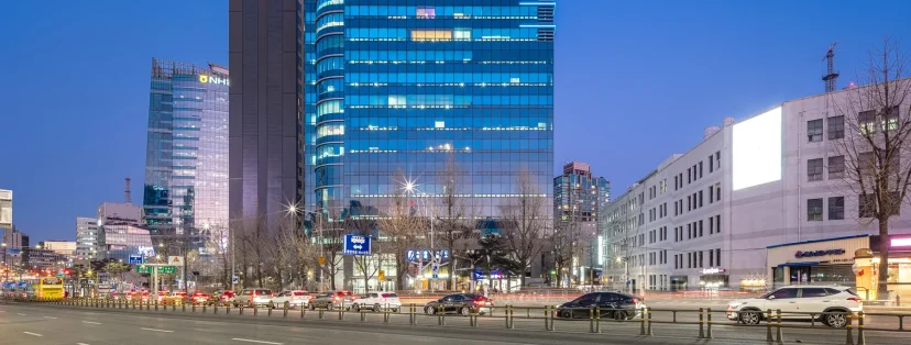 해 질 녘 불이 켜진 웨스트게이트타워와 서대문역 앞 큰길