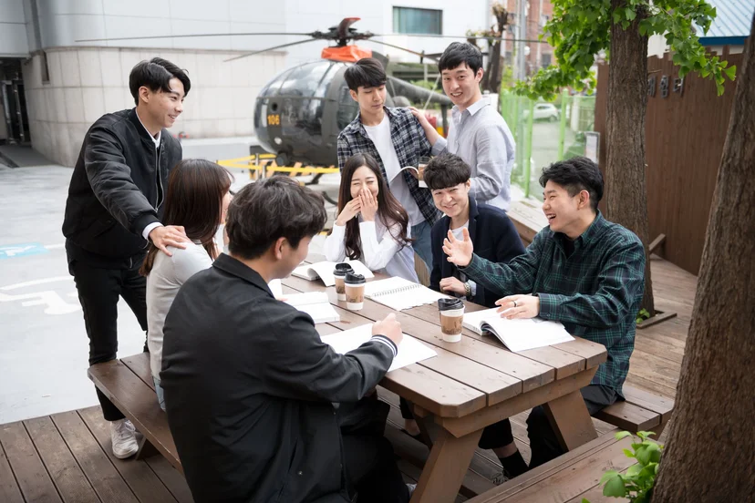 테이블에서 자료를 함께 보는 학생들