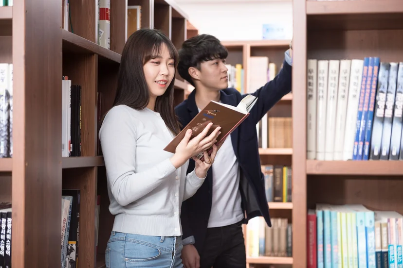 도서 서가 앞에서 책을 고르는 학생들