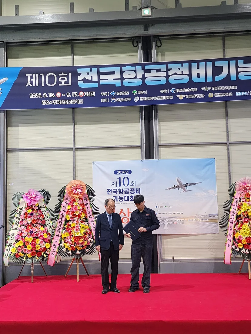 전국항공정비기능대회 무대 앞에서 수상 기념촬영을 하는 사람들