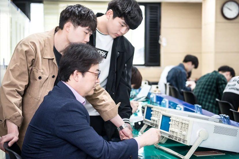 측정 장비 사용법을 설명하는 교수와 학생들