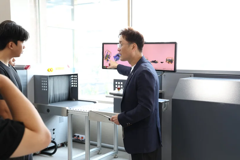 보안검색 실습실의 장비를 살펴보는 학생들