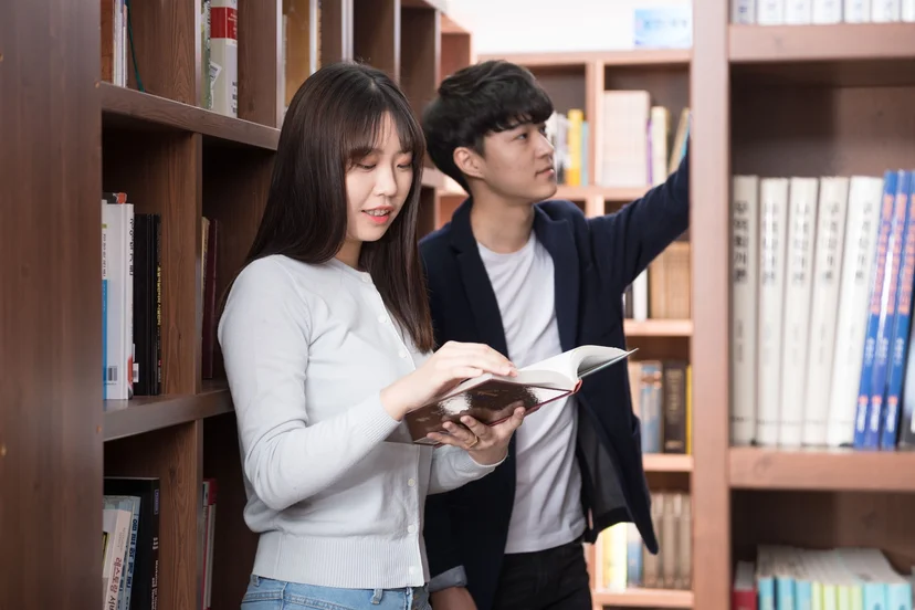책장 앞에서 책을 읽고 고르는 모습