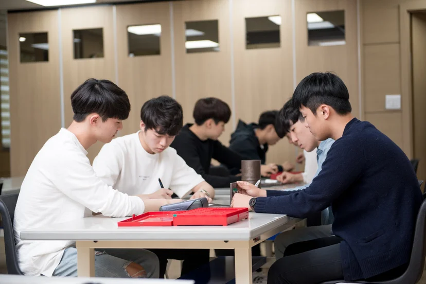 실습대에 둘러앉아 공구와 재료를 다루는 모습