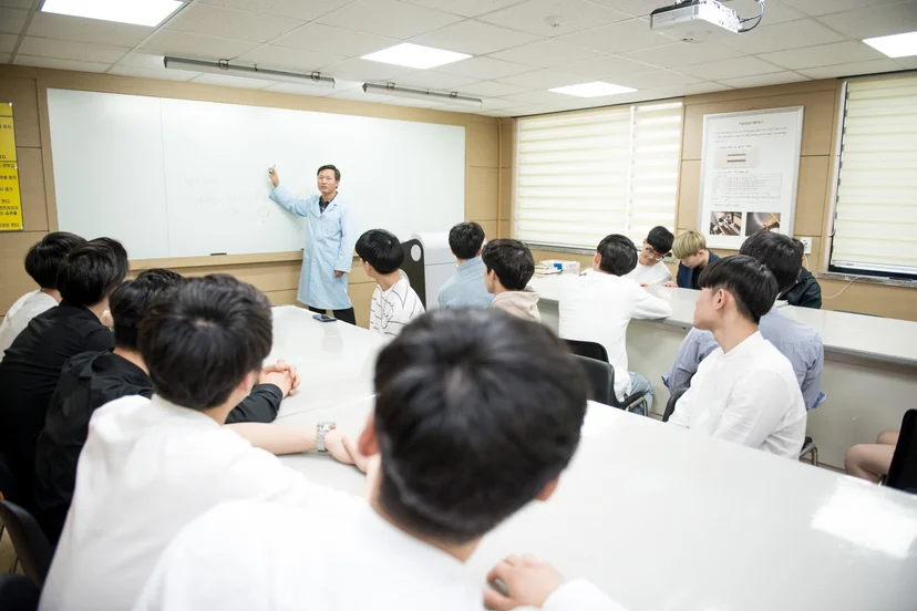 강의실 칠판 앞 설명을 듣는 사람들