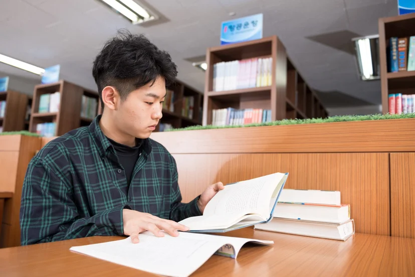책상에서 책을 펼쳐 읽는 학생
