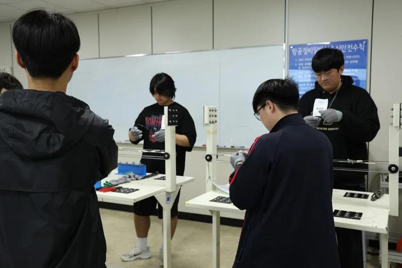 공구와 실습 재료를 살펴보는 학생들