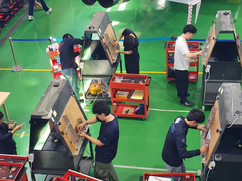 공구 카트 옆에서 실기 과제를 수행하는 참가자들