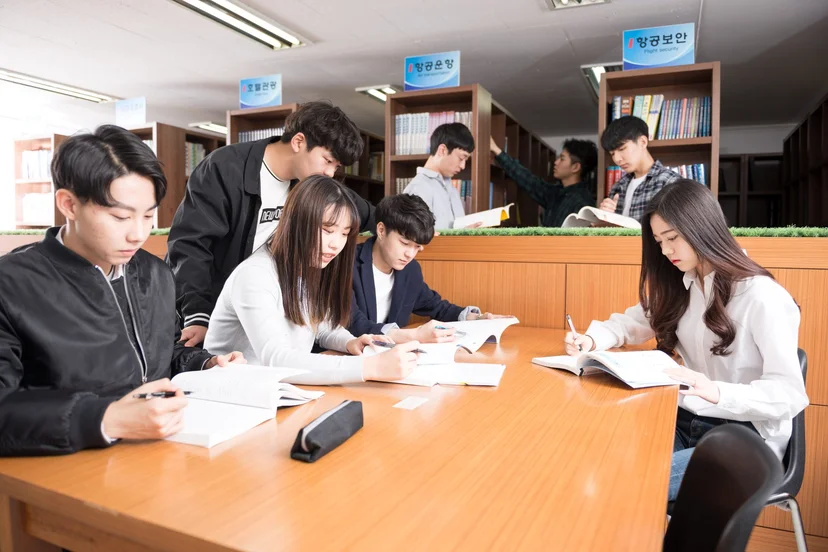 도서관 테이블에 둘러앉아 자료를 보는 학생들