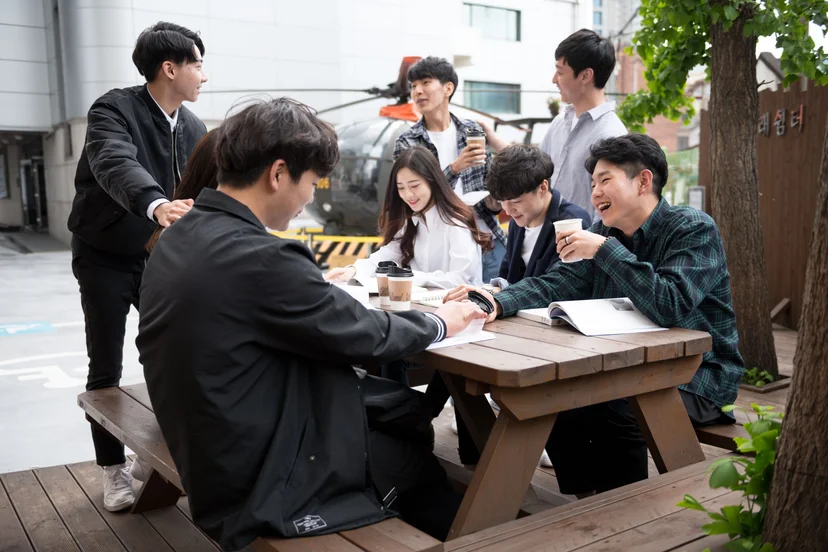 야외 테이블에 모여 함께 공부하는 학생들