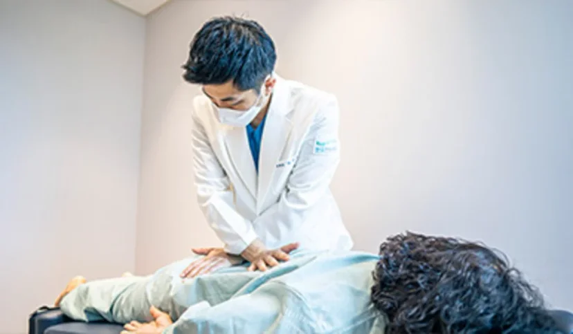 팔달구 교통사고 자동차보험 합의|환자의 허리 부위를 진료 및 수기 치료 중인 의료진