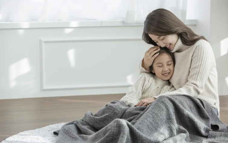 따뜻한 실내에서 서로를 안고 있는 엄마와 딸