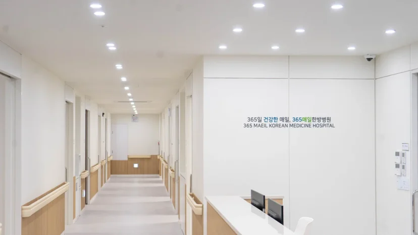 365매일한방병원의 깔끔한 내부 복도와 접수처 전경