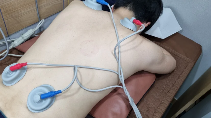 등과 허리 부위에 전기 자극 물리치료를 받는 모습