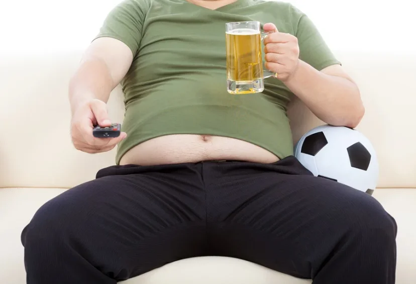 맥주를 마시며 TV를 시청하는 복부비만 남성