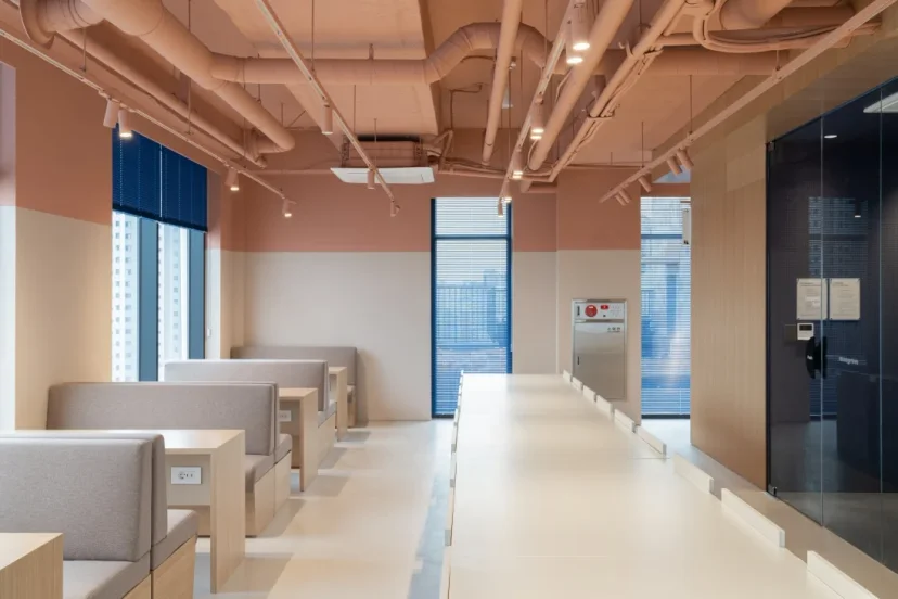 A shared workspace at a Mangrove location with booth seating, a long table, and power outlets by the windows