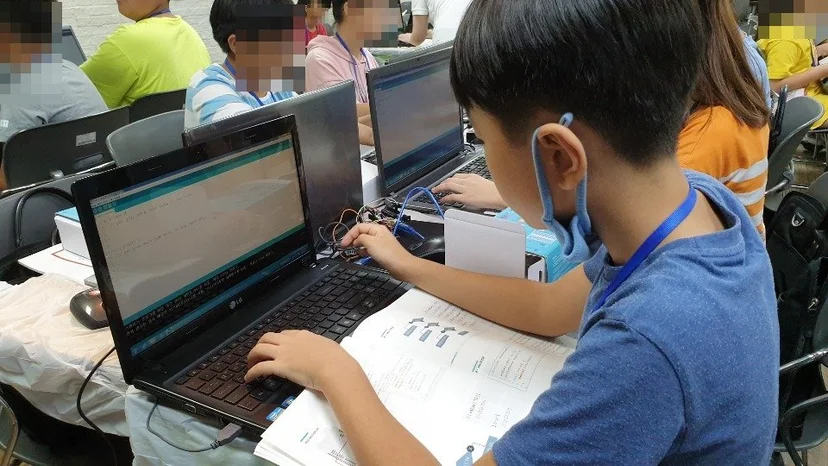 과정 교재를 보며 아두이노 코드를 입력하는 학생
