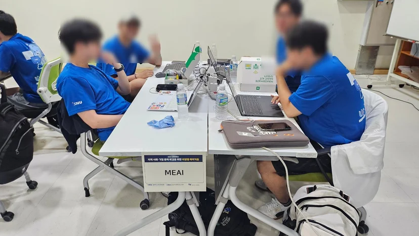 ‘MEAI’, ‘만들어조’처럼 팀 이름 안내판을 세운 테이블에서 논의하는 학생들
