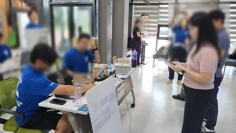 팀 테이블 옆에 발표 판을 세우고 시제품을 설명하는 모습