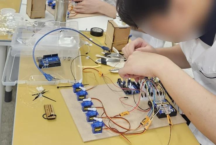 완성된 AI 손동작 인식 로봇의수를 테스트하는 학생