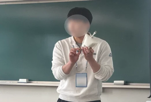 칠판 앞에서 완성한 시제품을 들고 기능을 설명하는 학생