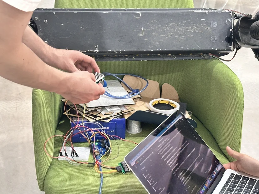 의자 위에 킥보드 부품과 LED 매트릭스를 놓고 코드를 수정하는 학생들