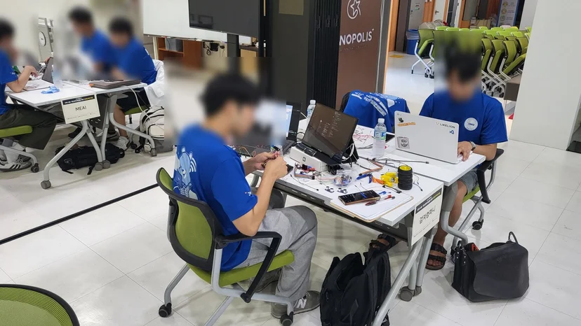 LCD에 문구를 띄운 아두이노 회로와 코드를 다듬는 팀원들