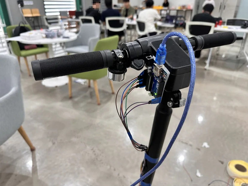 킥보드 핸들 중앙에 장착한 아두이노 보드와 USB 케이블