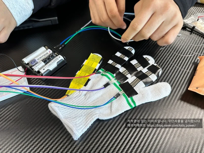 3D 프린터 파츠와 서보모터를 낚싯줄로 연결한 로봇의수
