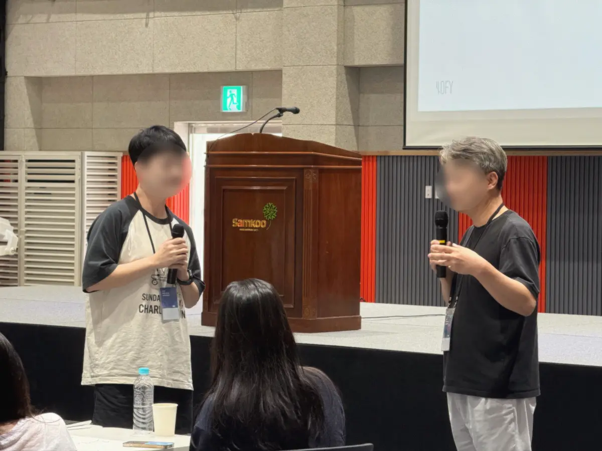 MPW Korea 팀빌딩 워크샵에서 참여자들이 마이크를 들고 발표를 진행하고 있다.