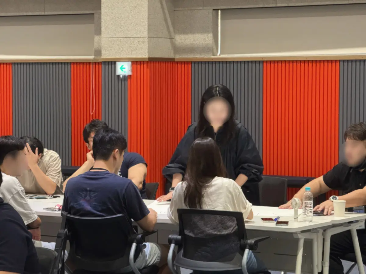 MPW Korea 직원들이 서로 밝은 얼굴로 대화하며 발표 내용을 논의하고 있다.