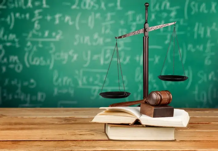 책상 위에 저울, 의사봉, 책이 놓여 있는 이미지로 법정의무교육을 상징