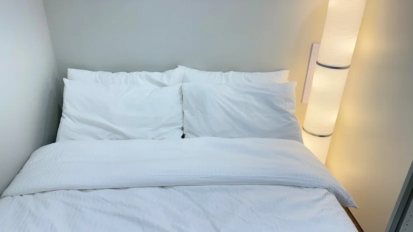 Queen bed with white bedding and a reading lamp (Listing ID : 30596)