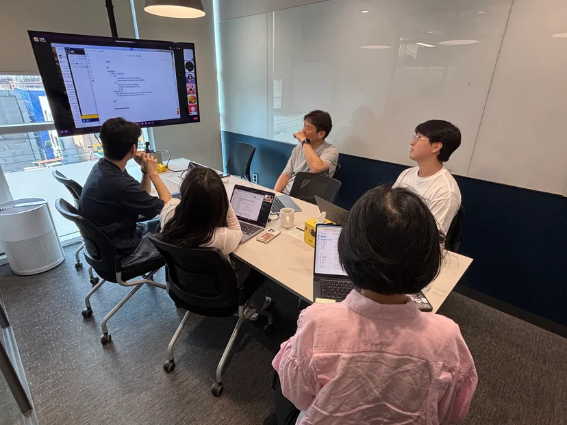 AI 도구 도입 3개월 후, 주식회사 텐 CPO 조직 구성원들이 회의실에서 노트북과 화면을 보며 개발·기획 업무 변화에 대해 논의하는 모습.