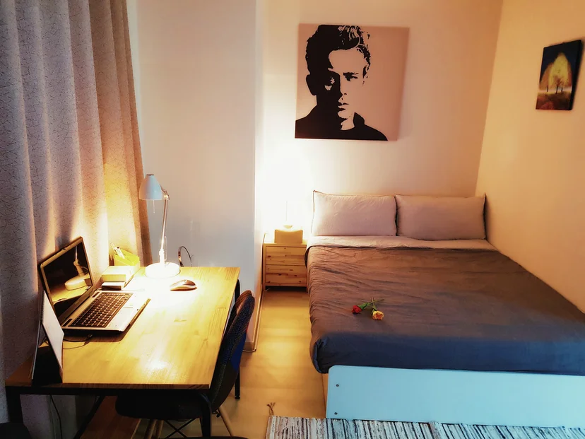 Warm-lit room with a double bed, a wooden study desk and a reading lamp (Listing ID : 25)