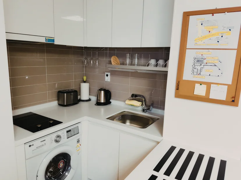 Compact kitchen with an induction cooktop, a sink and an in-unit washer below the counter (Listing ID : 25)