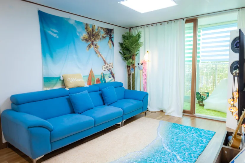 Bright living room with a blue sofa and glass balcony door (Listing ID : 4764)