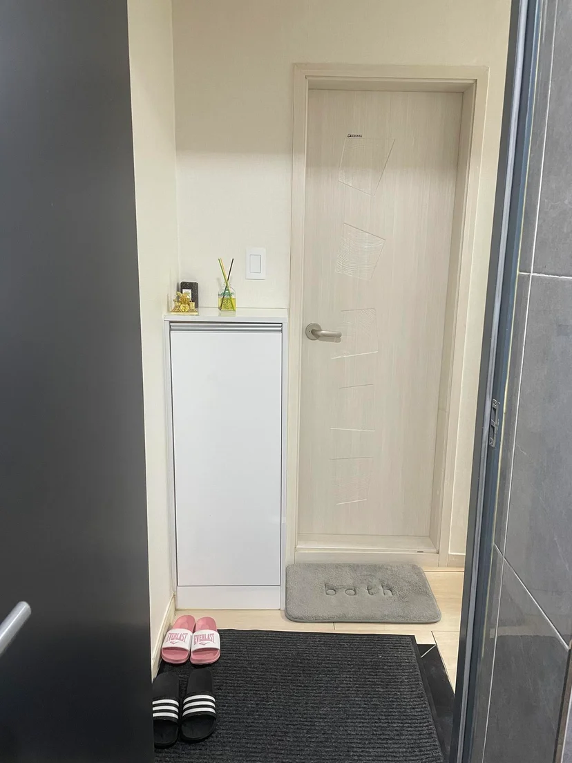 Entryway with a shoe cabinet, slippers on the mat and the private bathroom door (Listing ID : 17562)