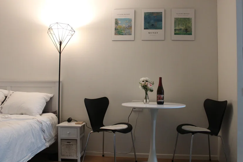 Studio bedroom with bed, floor lamp, bistro table and Monet wall art (Listing ID : 17787)