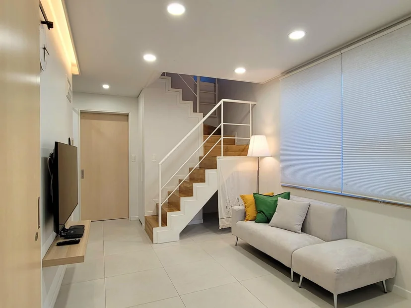 Living room with a staircase up to the loft and a sofa (Listing ID : 17400)