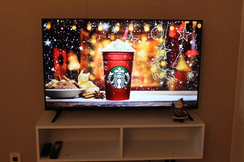 Wall-mounted flat-screen TV on a white console with remotes (Listing ID : 17787)